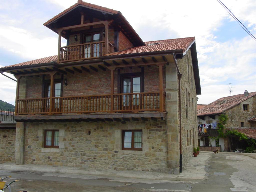 une maison avec un balcon au-dessus dans l'établissement Las Anjanas de Lloreda, à Lloreda