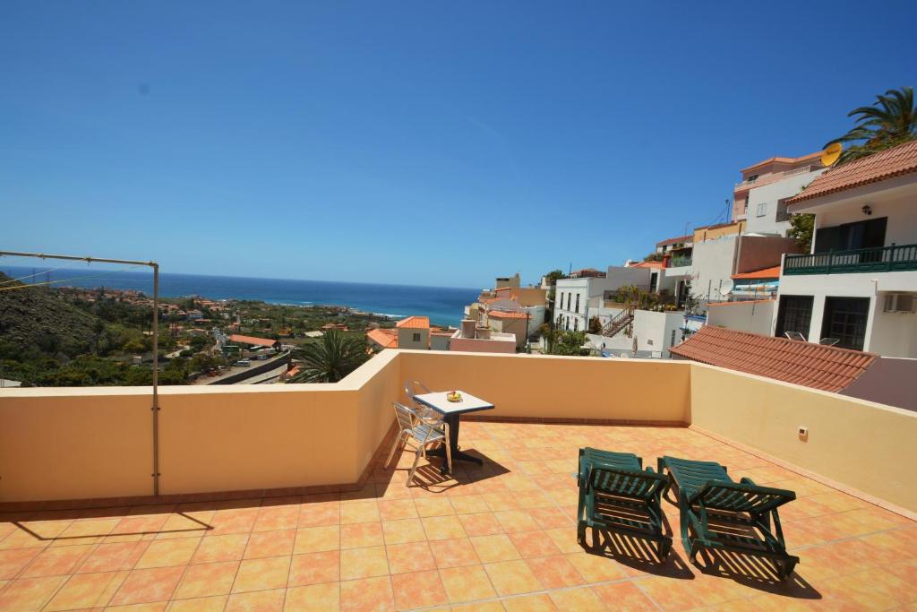 a patio with two chairs and a table on a balcony at Apartamentos Andrea in Calera