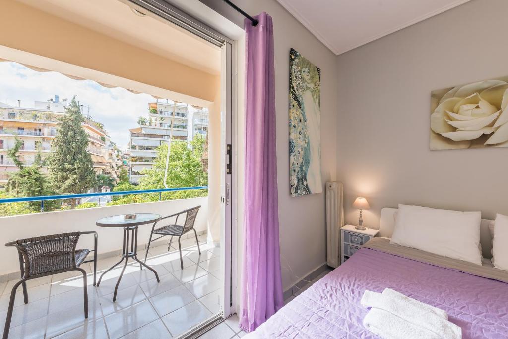 - une chambre avec un lit et un balcon avec une table dans l'établissement Zenios Kisamos-Pretty comfy studio, à Athènes
