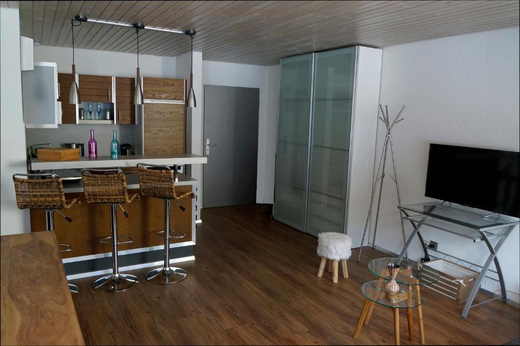 a living room with a table and a tv in it at Bannwaldseestudio in Halblech