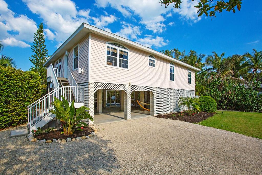a large white house with a large driveway at Stunning Newly Designed and Renovated Home seconds to the Gulf Of Mexico in Sanibel