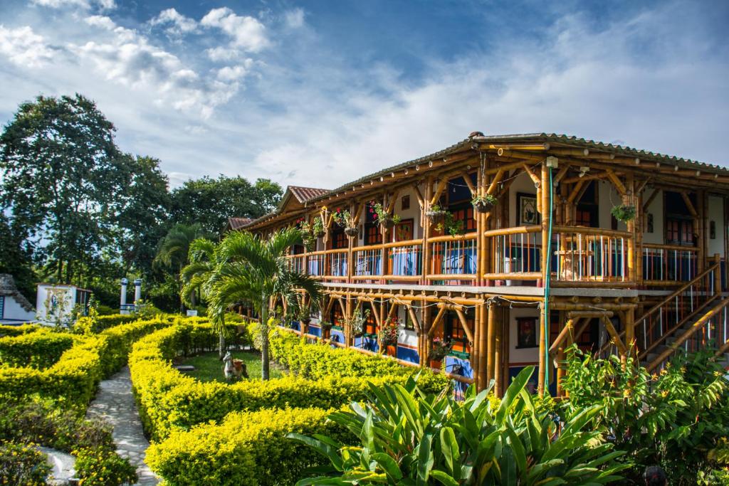 een houten huis met een tuin ervoor bij Finca Hotel La Dulcera in Armenia