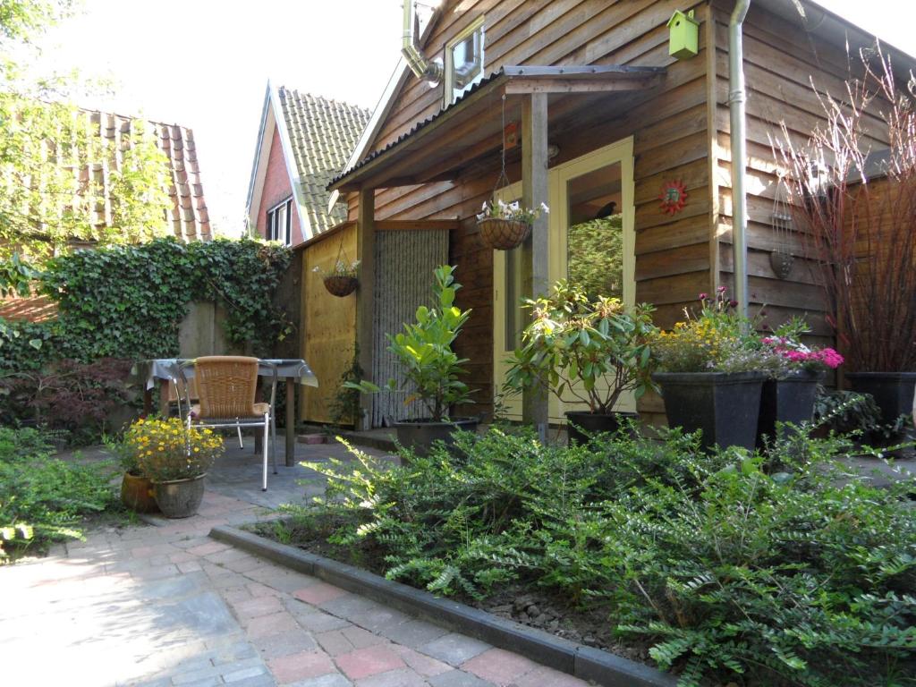 een tuin buiten een houten huis met planten bij Appartement Regina in Garnwerd