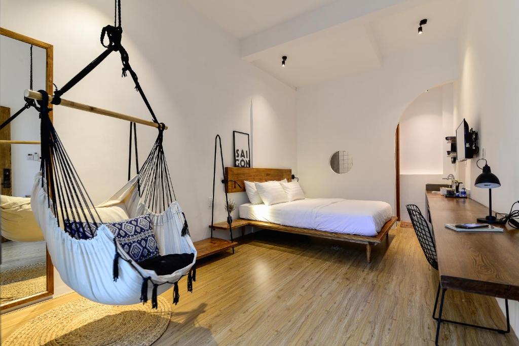 a room with a bed and a hammock at Leaf Signature Hotel - Lá Group in Ho Chi Minh City