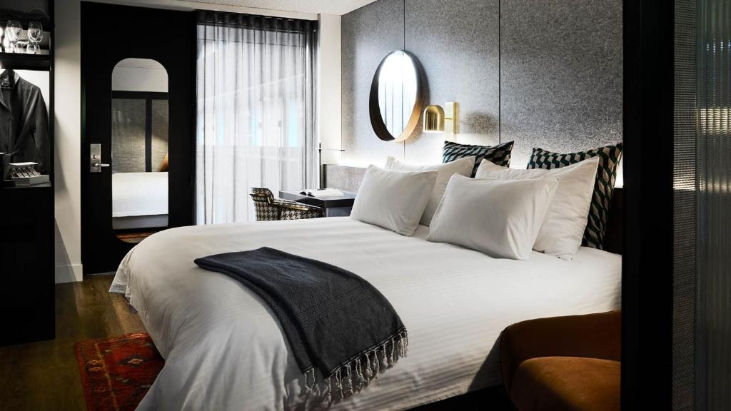 a hotel room with a large bed and a large mirror at Zagame's House in Melbourne
