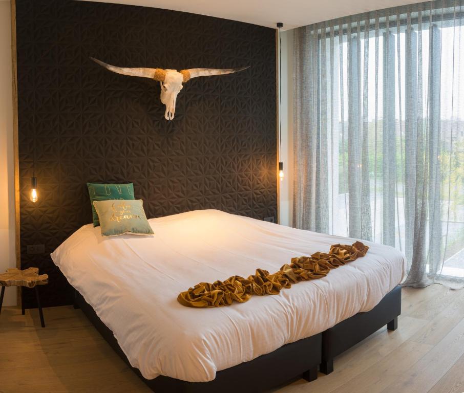 a bedroom with a large bed with aulture hanging on the wall at Hotel Shamrock in Tielt