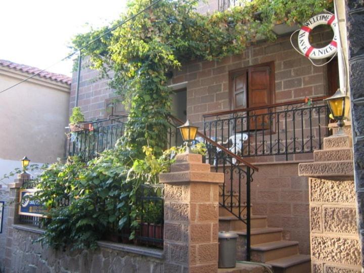 un edificio de ladrillo con escaleras y plantas. en Machi's Guest House, en Mithimna