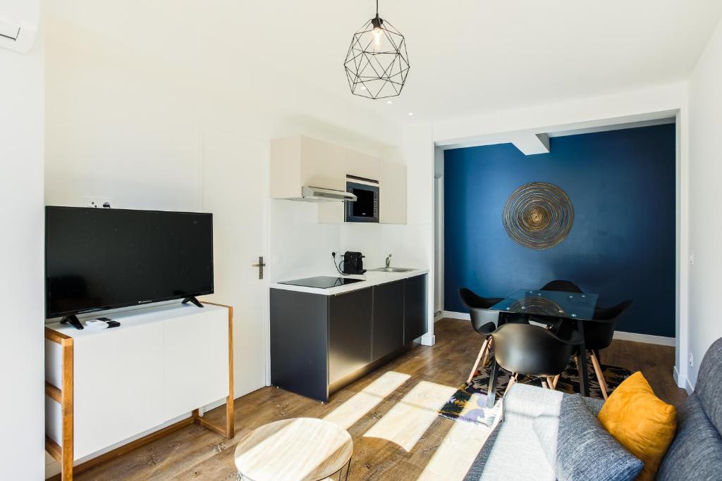 un salon avec un canapé et une télévision dans l'établissement Rossini Centre Ville - Proche Tram, à Nice