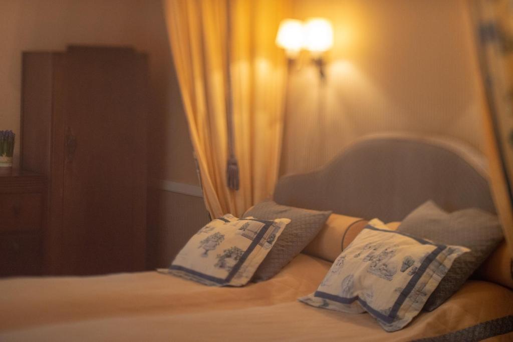 - une chambre avec un lit doté d'oreillers bleus et blancs dans l'établissement Wanha Kartano, à Kokkola