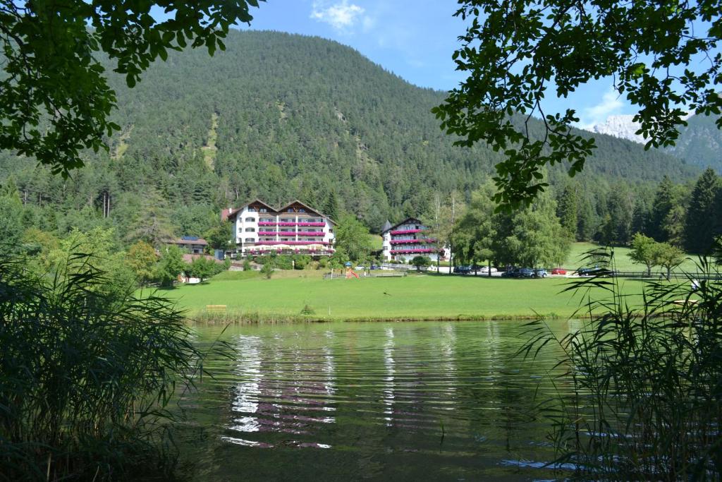 a view of a resort with a lake and buildings at Alpenhotel Linserhof in Imst