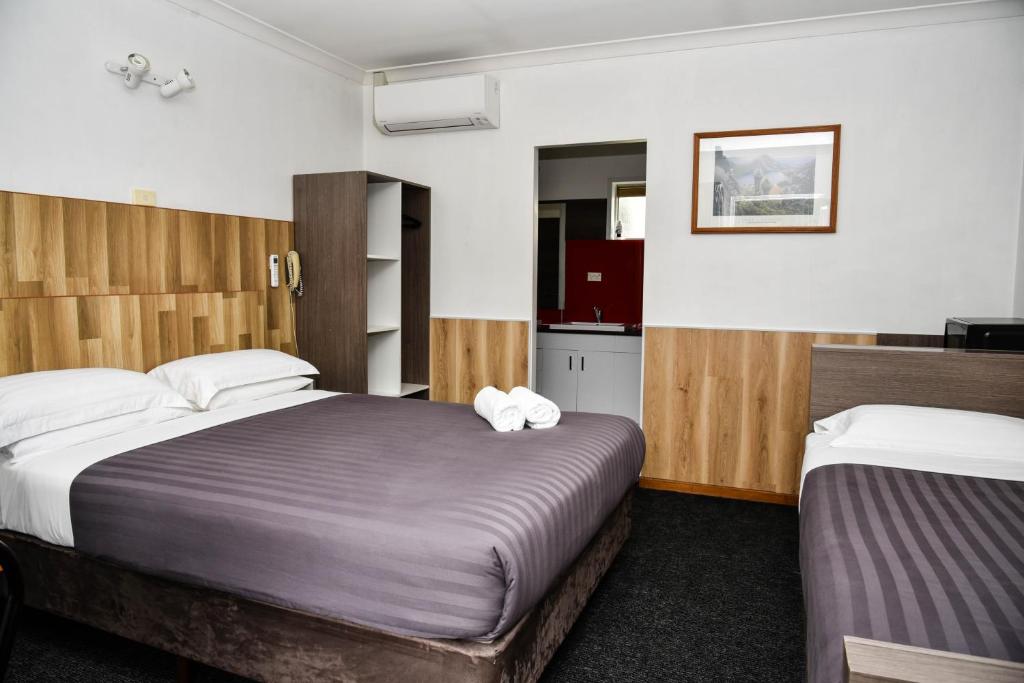 Postel nebo postele na pokoji v ubytování Hobart Tower Motel