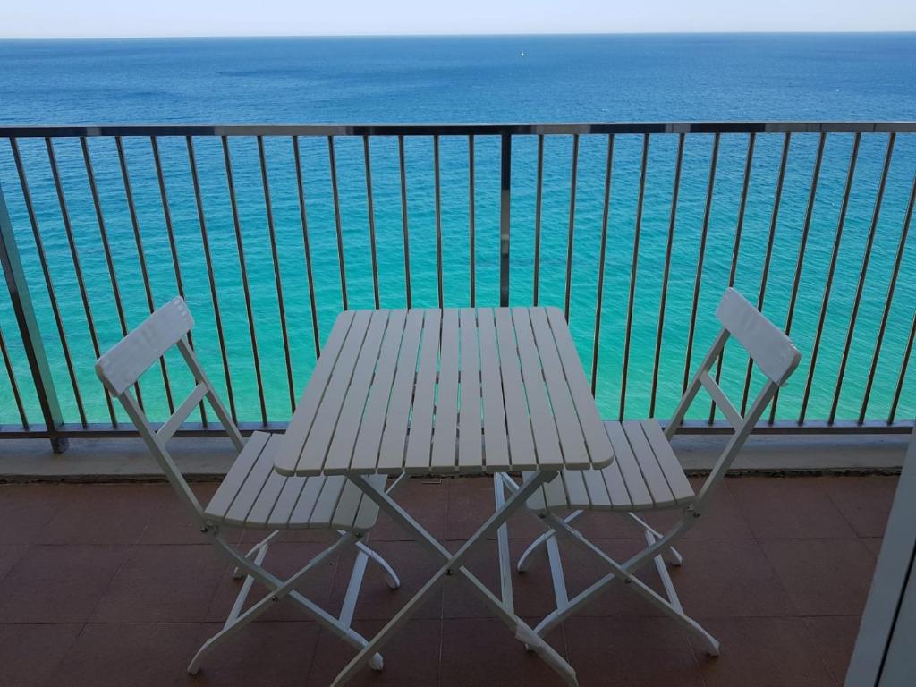 una mesa y sillas en un balcón con vistas al océano en Apartamento en primera linia vistas al mar en Platja  d'Aro