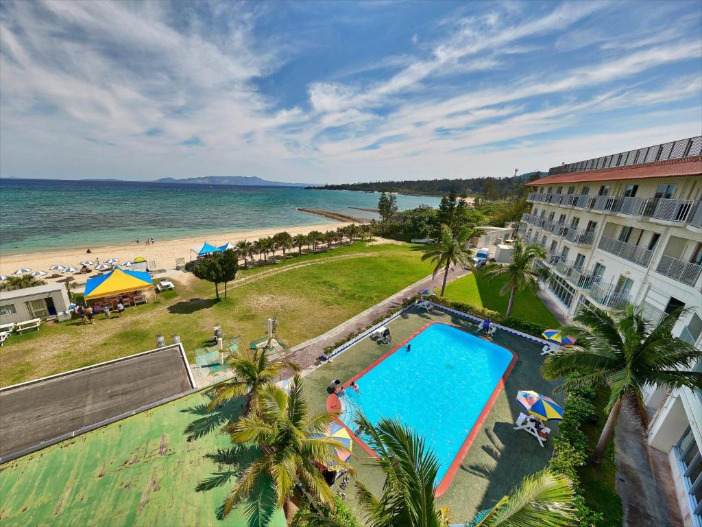 an aerial view of a resort with a swimming pool and the beach at Miyuki Hamabaru Resort in Onna