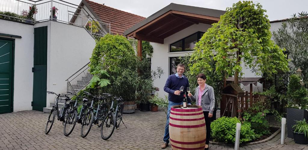 Um homem e uma mulher à frente de um barril. em Weingut Familie Bauer em Großriedenthal