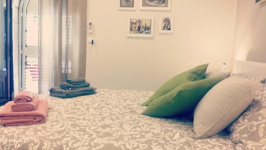 een bed met kussens en handdoeken erop bij Casa Cleone in Taormina
