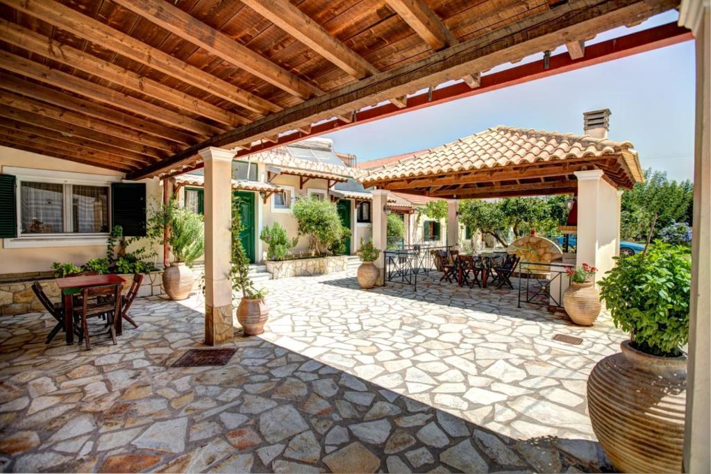 an outdoor patio with a wooden pergola at Trident Studios and Apartments in Kavos