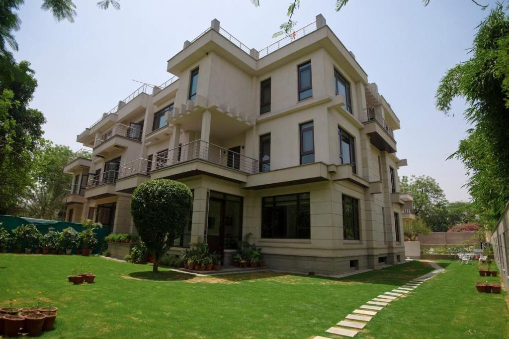 a large white house with a green yard at 76 Friends Colony in New Delhi