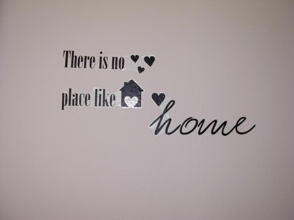 a wall with a home sticker with a house and hearts at Apartments Kiro in Milna
