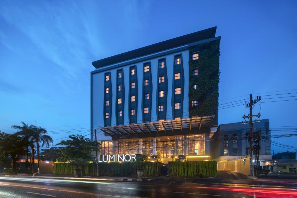a building with a lit up sign at night at Luminor Hotel Airport Sidoarjo By WH in Sidoarjo