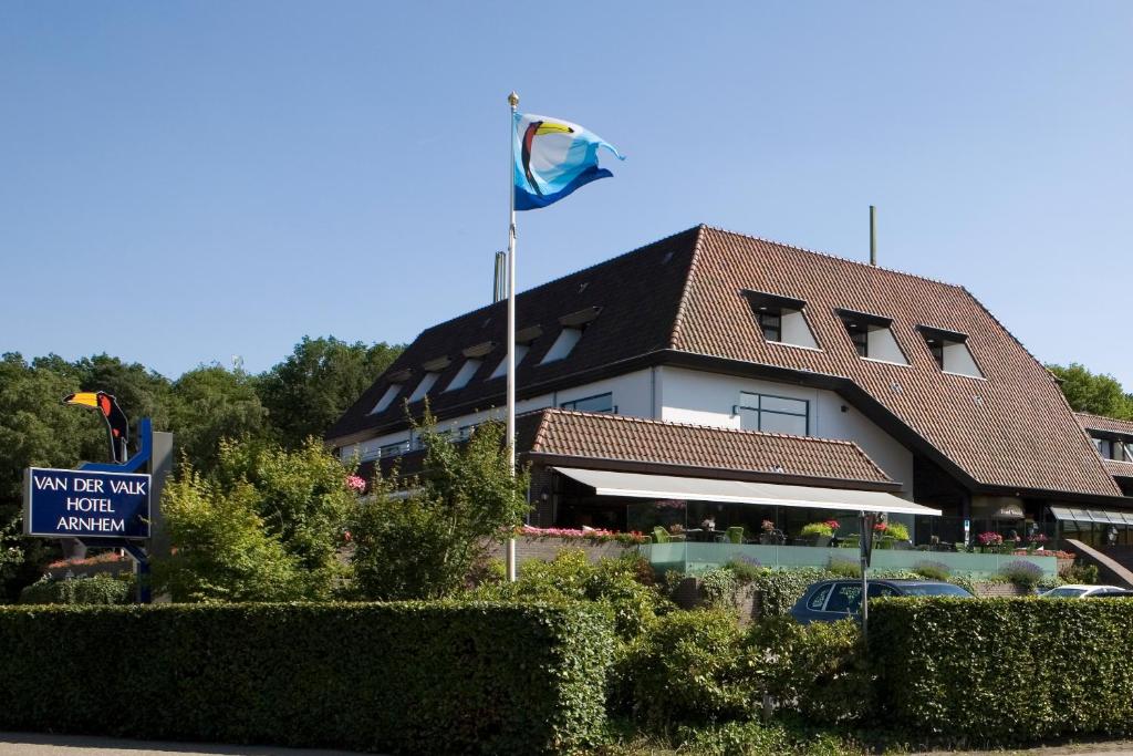 a building with a blue flag in front of it at Van der Valk Hotel Arnhem in Arnhem