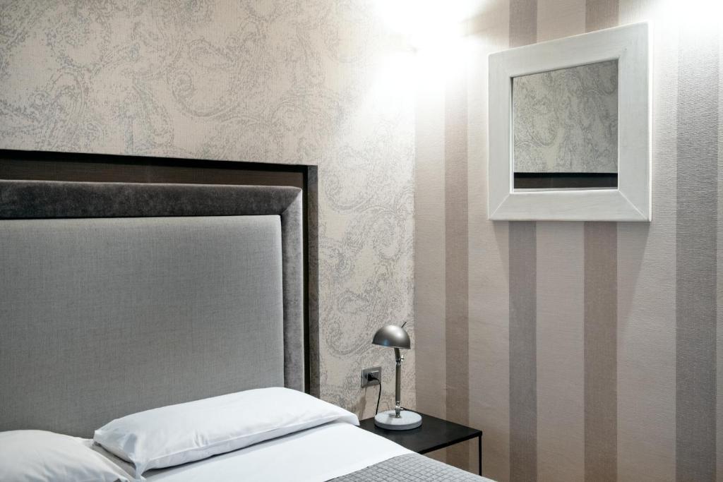 a bedroom with a bed and a picture on the wall at Hotel Salus in Pescara