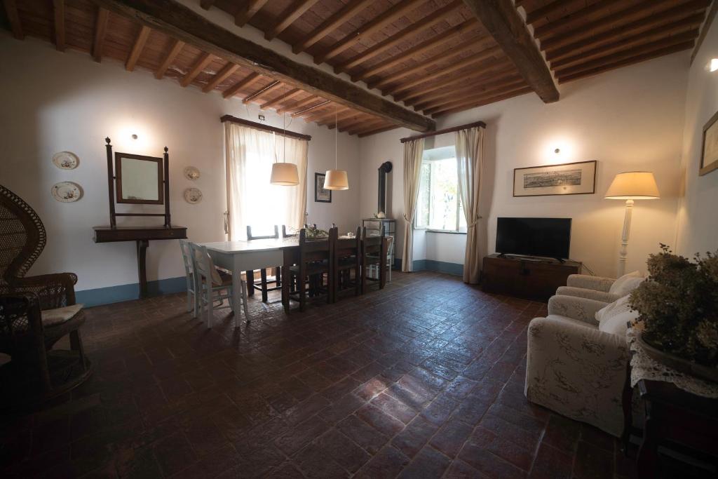 ein Wohnzimmer mit einem Tisch, Stühlen und einem Sofa in der Unterkunft Casale Amati Country House in Ortonovo