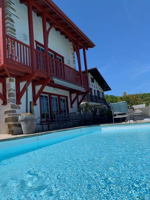 eine Villa mit einem Pool vor einem Haus in der Unterkunft MAXANA in Labastide-Clairence