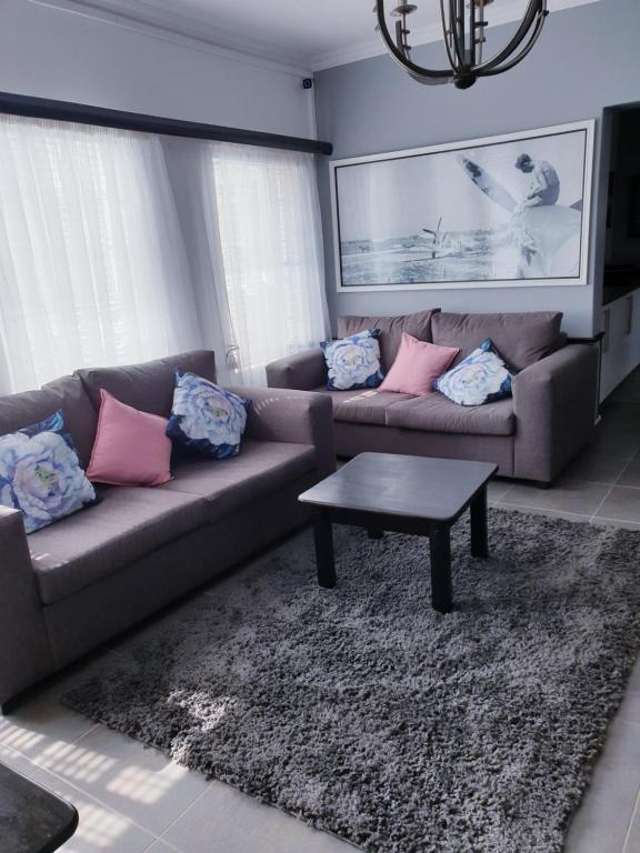 a living room with two couches and a coffee table at Hiflyerz Guest House in Boksburg