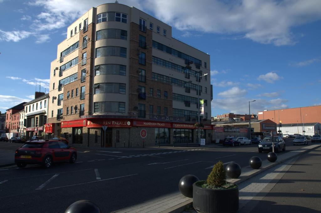 a tall building on a city street with cars parked at City Centre Apartment in Derry Londonderry