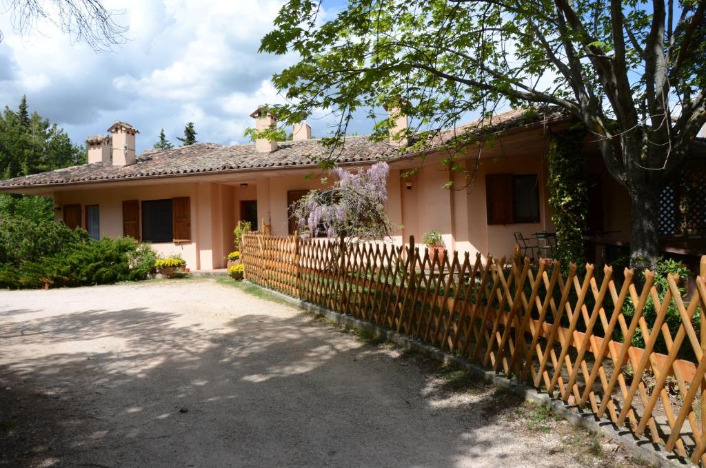 una casa con una valla delante de ella en Le ginestre en San Severino Marche