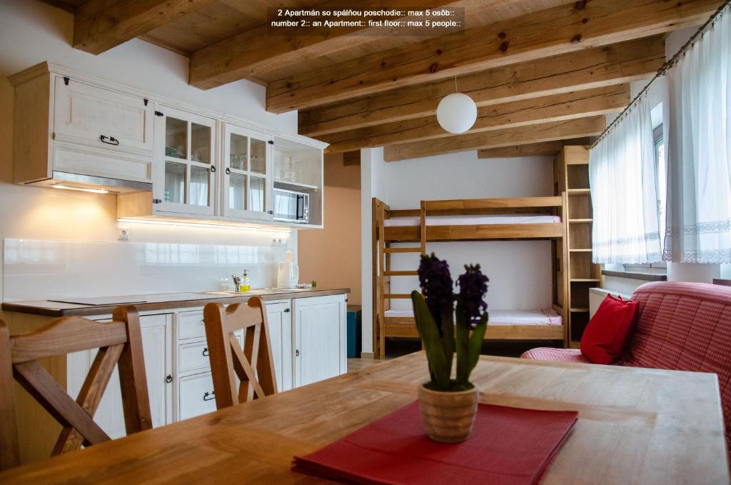 cocina y sala de estar con mesa y loft en Quota 1010, en Vysoke Tatry - Horny Smokovec