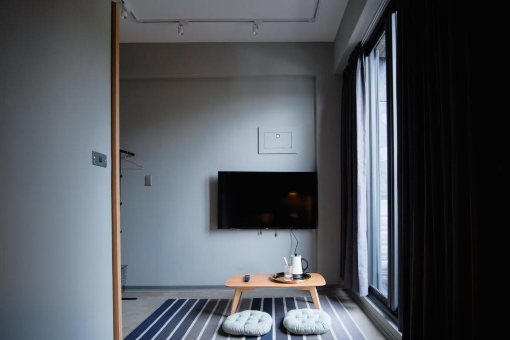 a living room with a table and a tv at Spangle Inn in Keelung