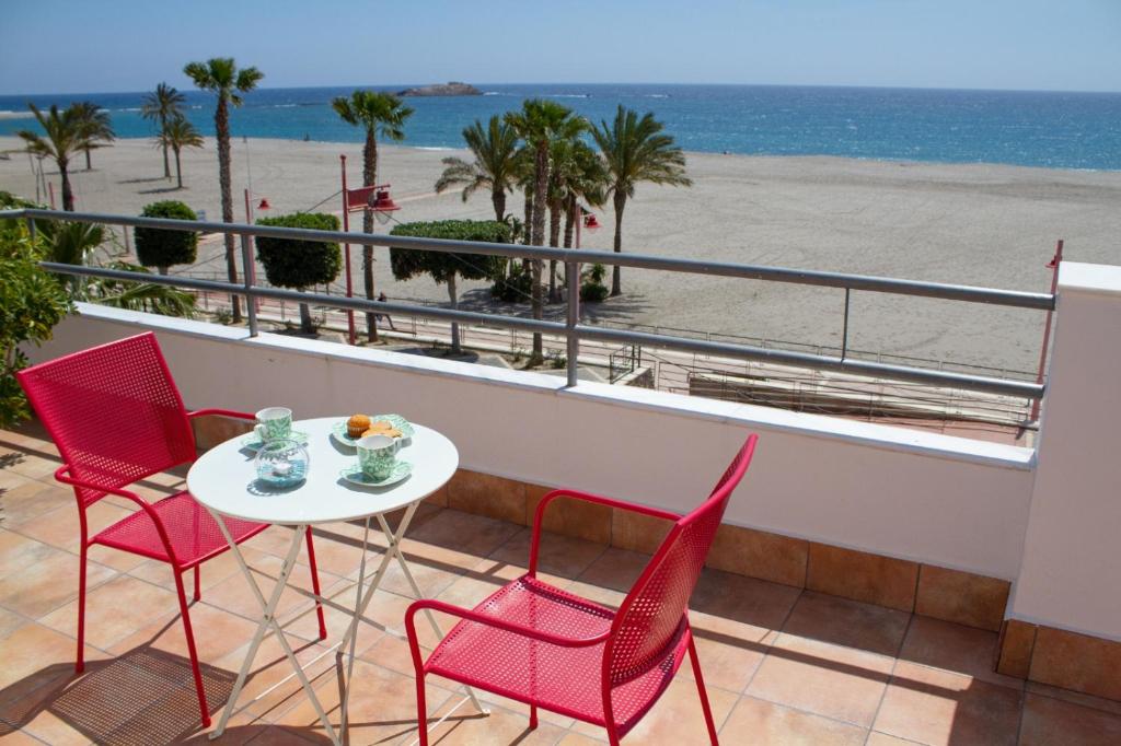 einen Balkon mit einem Tisch und Stühlen sowie Strandblick in der Unterkunft Habitaciones Hernández in Carboneras