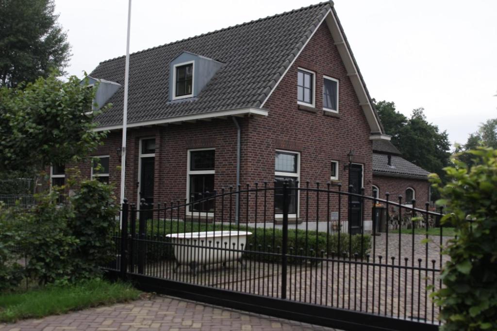 a red brick house with a black fence at NeyenGreve in Bennekom