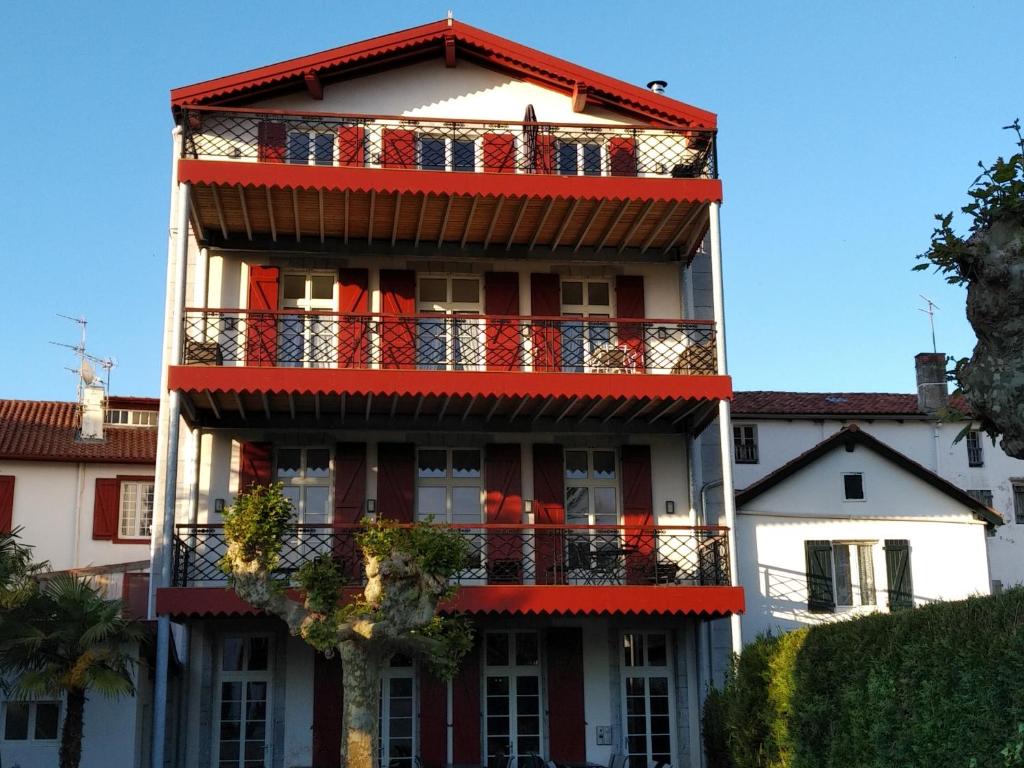 a building with a balcony with american flags on it at Jondoni Laurendi Kanbo in Cambo-les-Bains
