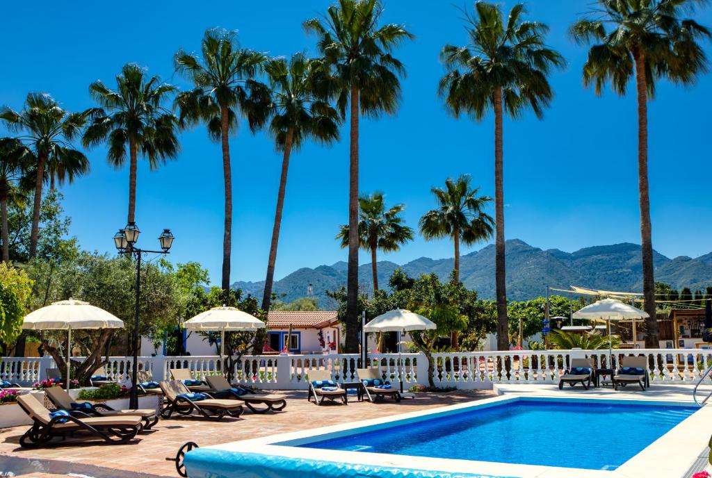 a pool at a resort with palm trees at The Palms Boutique Resort Málaga - Adults Only in Alhaurín de la Torre