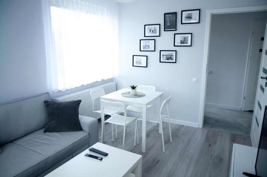 een woonkamer met een bank en een tafel bij Apartament Wiesio in Gdynia