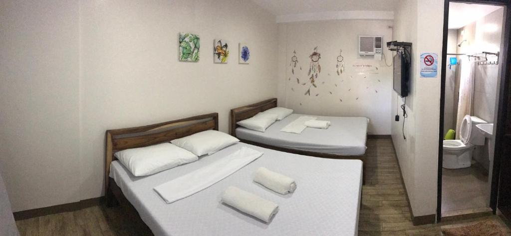 2 łóżka pojedyncze w pokoju z łazienką w obiekcie Seabreeze Beach Lodge w mieście Nasugbu