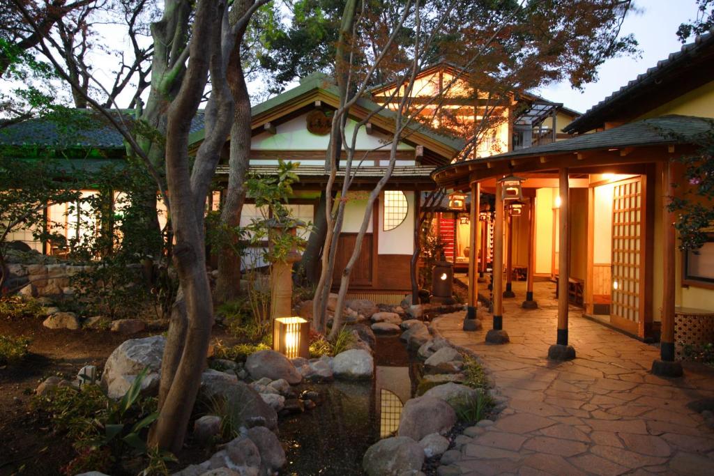 a house with a walkway in front of a building at Kappo Ryokan Kannawa Bettei in Beppu