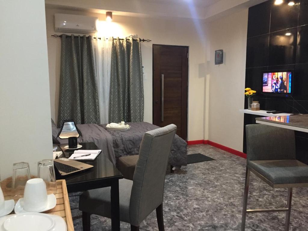 een kamer met een eettafel en een televisie bij Mirasol Residences in Daet