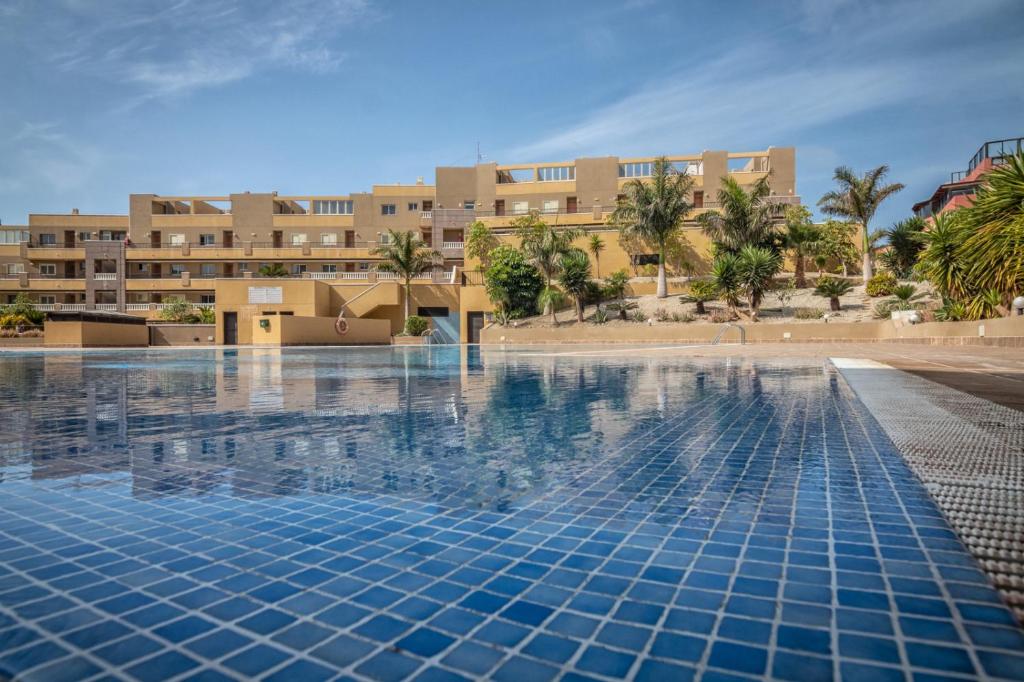 une piscine en face d'un bâtiment dans l'établissement El Medano La Perla C7, à El Médano