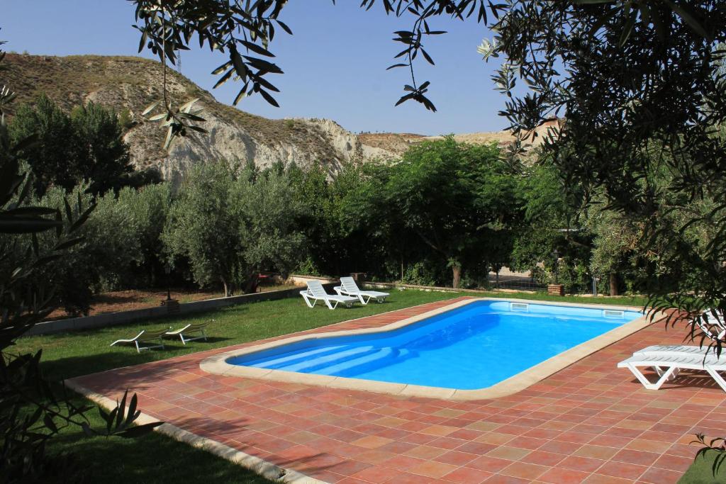 a swimming pool in a yard with a mountain in the background at Apartamentos La Suerte in Hinojares