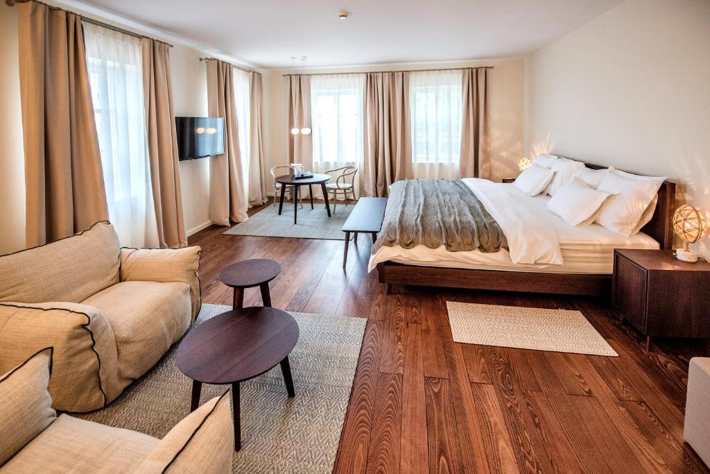 a bedroom with a large bed and a living room at Boutique Hotel Boškinac in Novalja