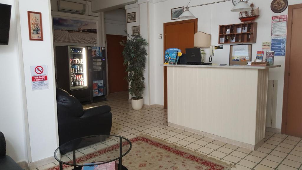 eine Lobby mit einer Bar, einem Stuhl und einer Theke in der Unterkunft Albergo Pensione Ardenza SELF CHECK-IN in Livorno