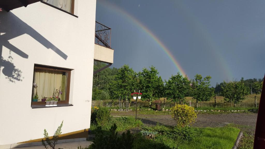 a rainbow in the sky behind a building at Pensiunea Diva in Cacica