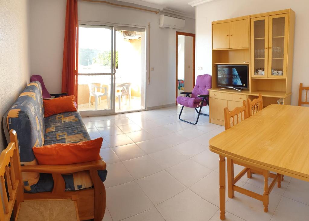 ein Wohnzimmer mit einem Sofa und einem Tisch in der Unterkunft Apartamento Playa Lo Pagán in Lo Pagán