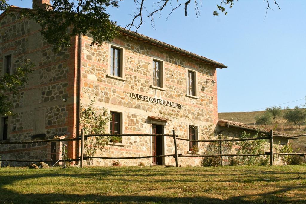 um velho edifício de tijolos com um cartaz em Villa Conte Gualtiero em Sarteano