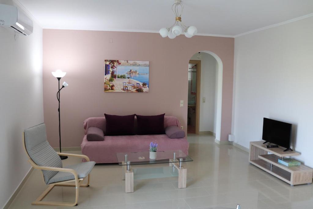 ナフプリオにあるARIA Luxury Apartmentsのリビングルーム(ピンクのソファ、テーブル付)