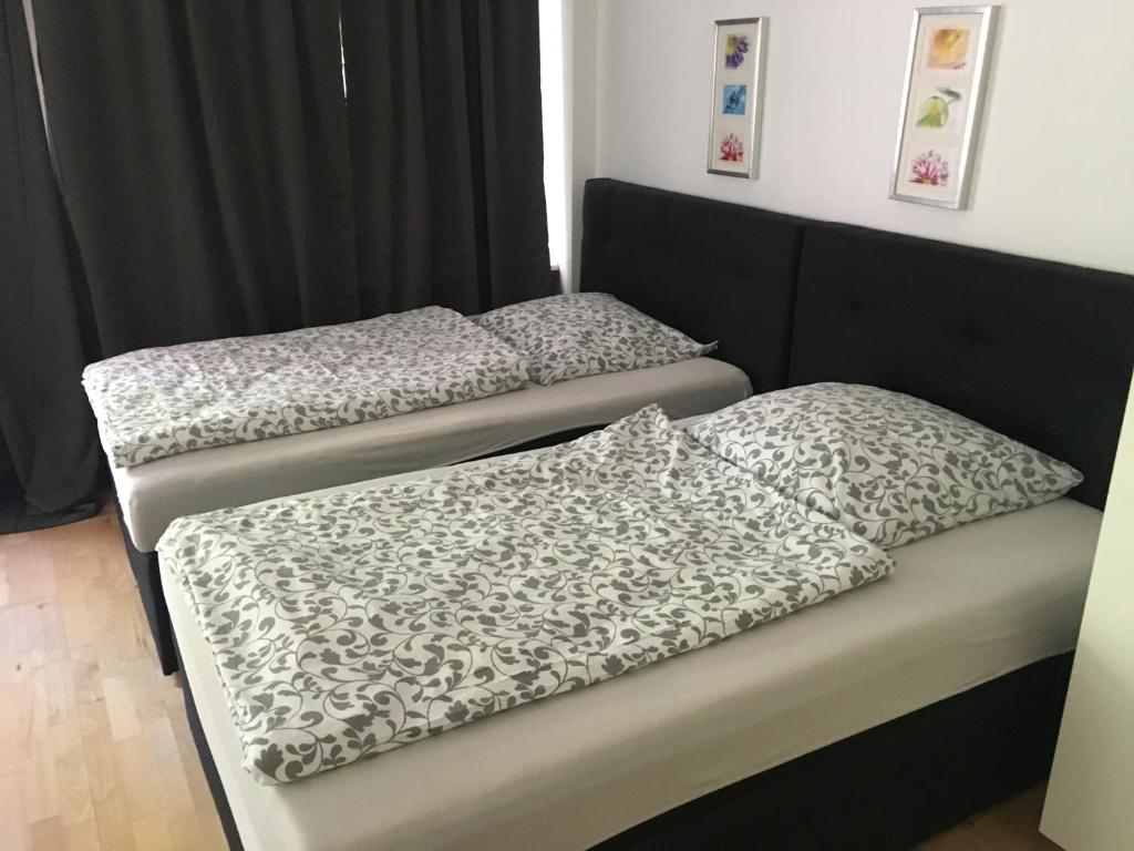 two beds in a room with black and white sheets at Dorya am Ring in Cologne
