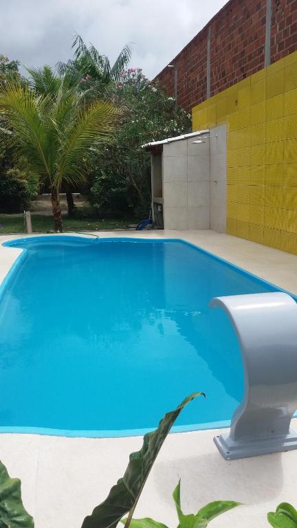 uma piscina azul com WC em frente a um edifício em Espaço verde Hospedagem em Araruama